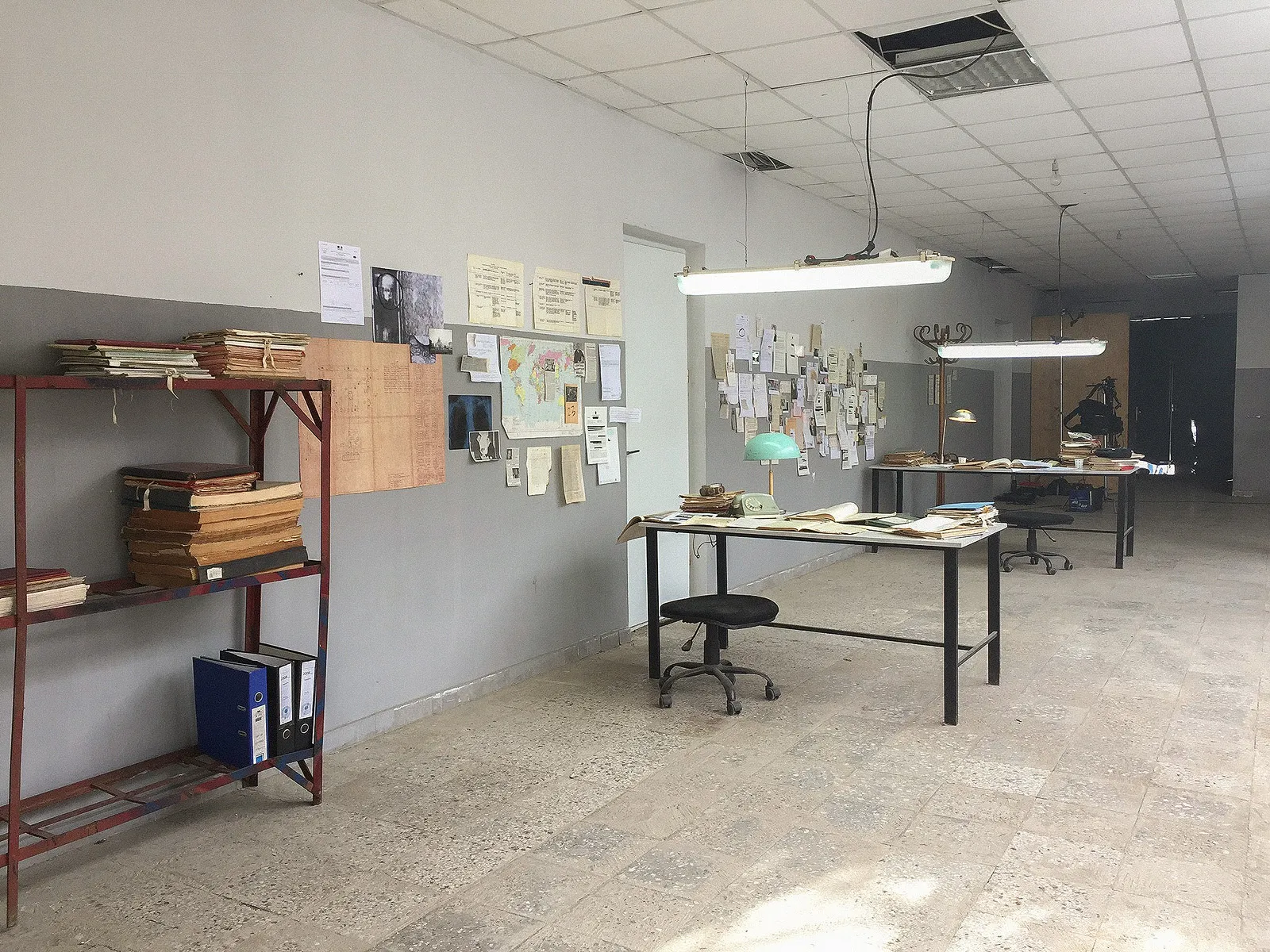 The finished set: desks, shelves of files, lamps and papers on the walls.