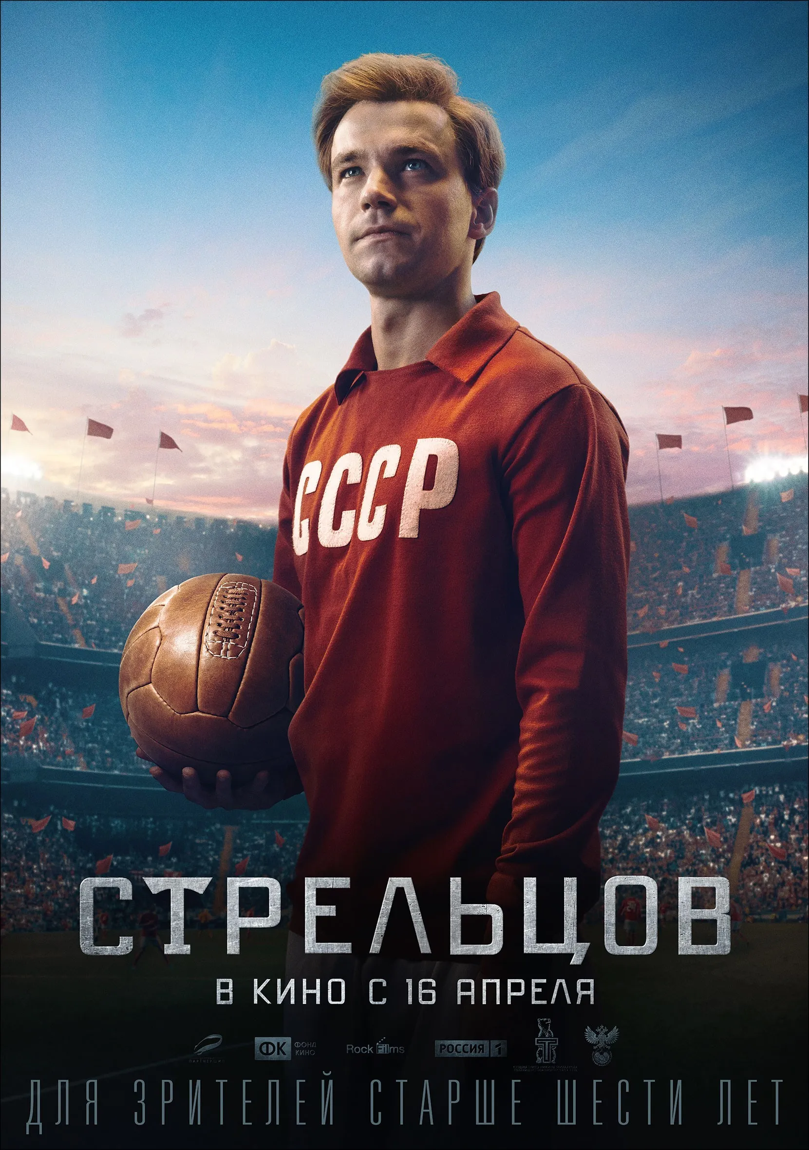 Upright poster: the lead actor holds a football in a red Soviet team shirt above a stadium.