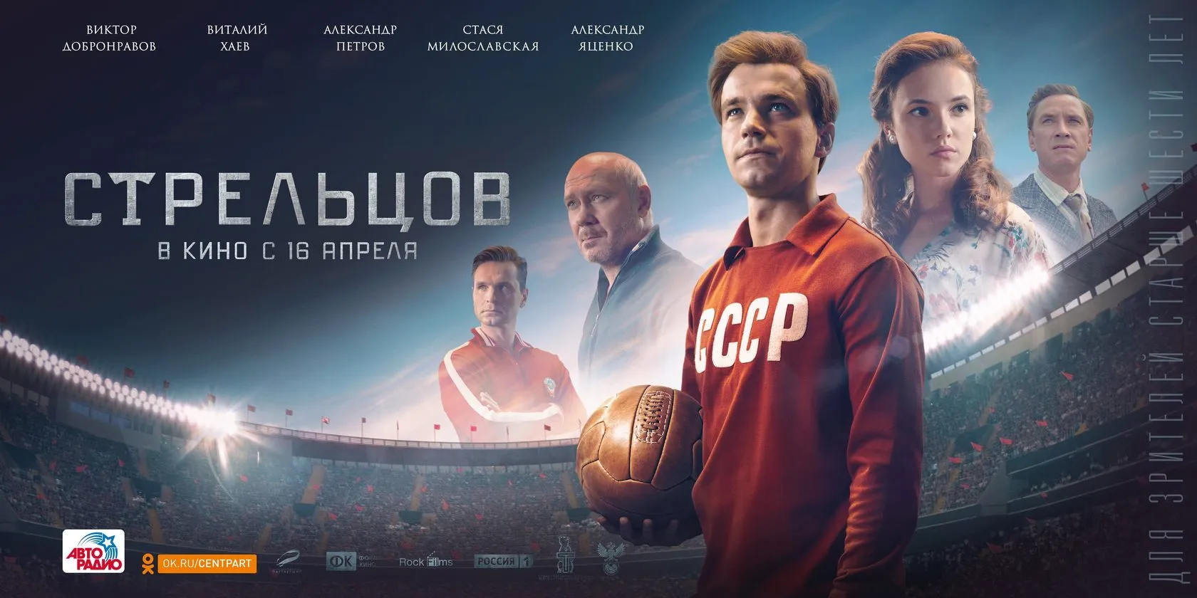 Wide poster: the cast behind the lead actor with a football, under stadium lights.
