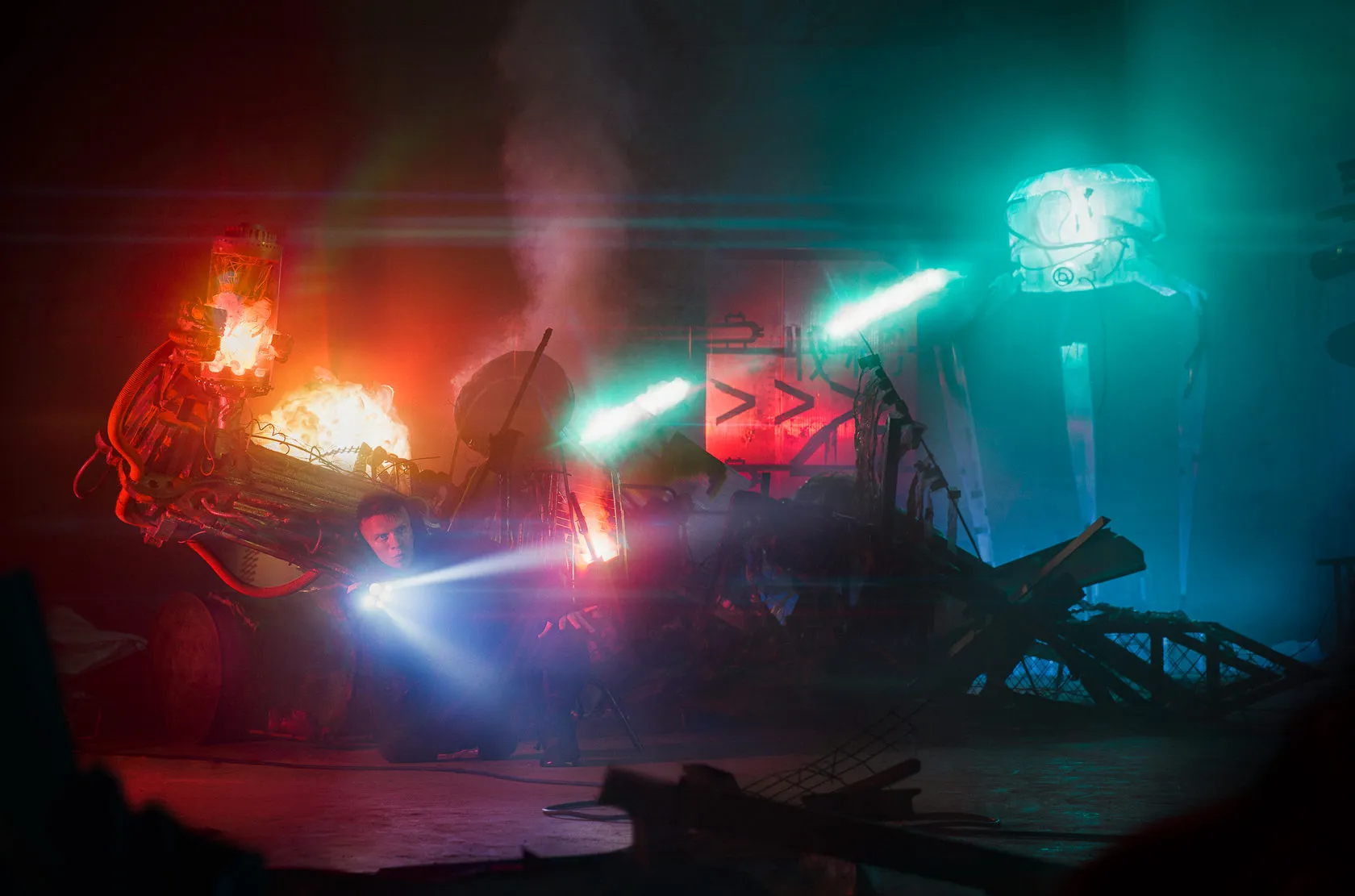 The Robo-Tomb Raider crouches with a torch among glowing wreckage as battle droids close in.