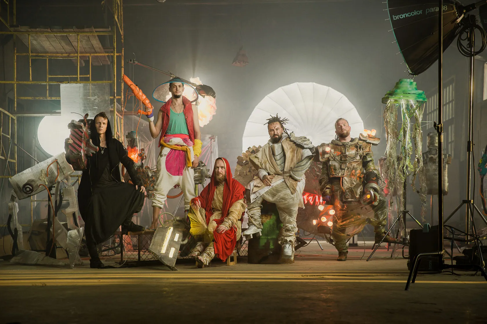 The five characters pose together on the studio set among lights, props and a glowing jellyfish.