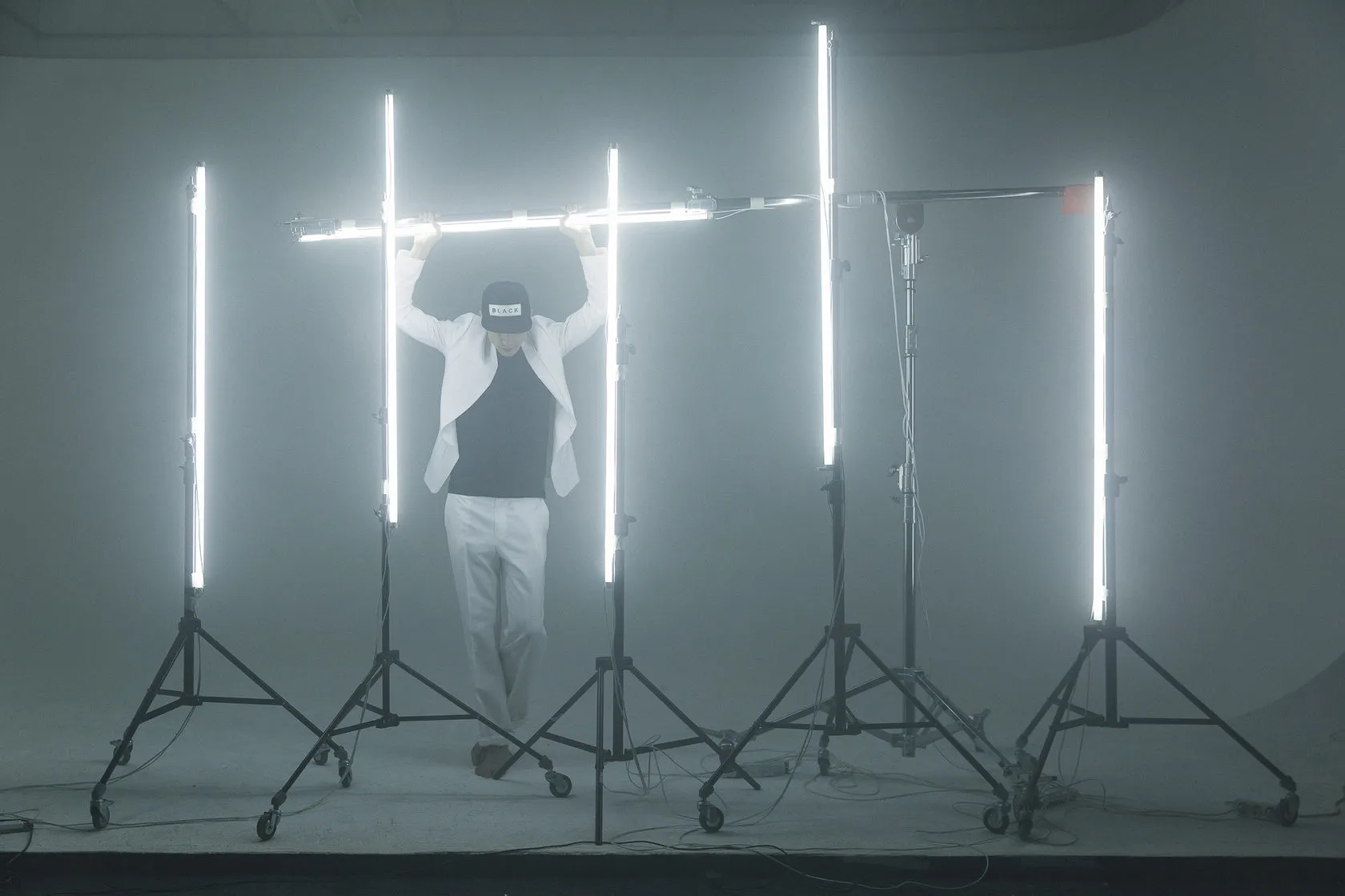 Pavel Ruminov stands among tall fluorescent tubes, his face hidden behind a placard.
