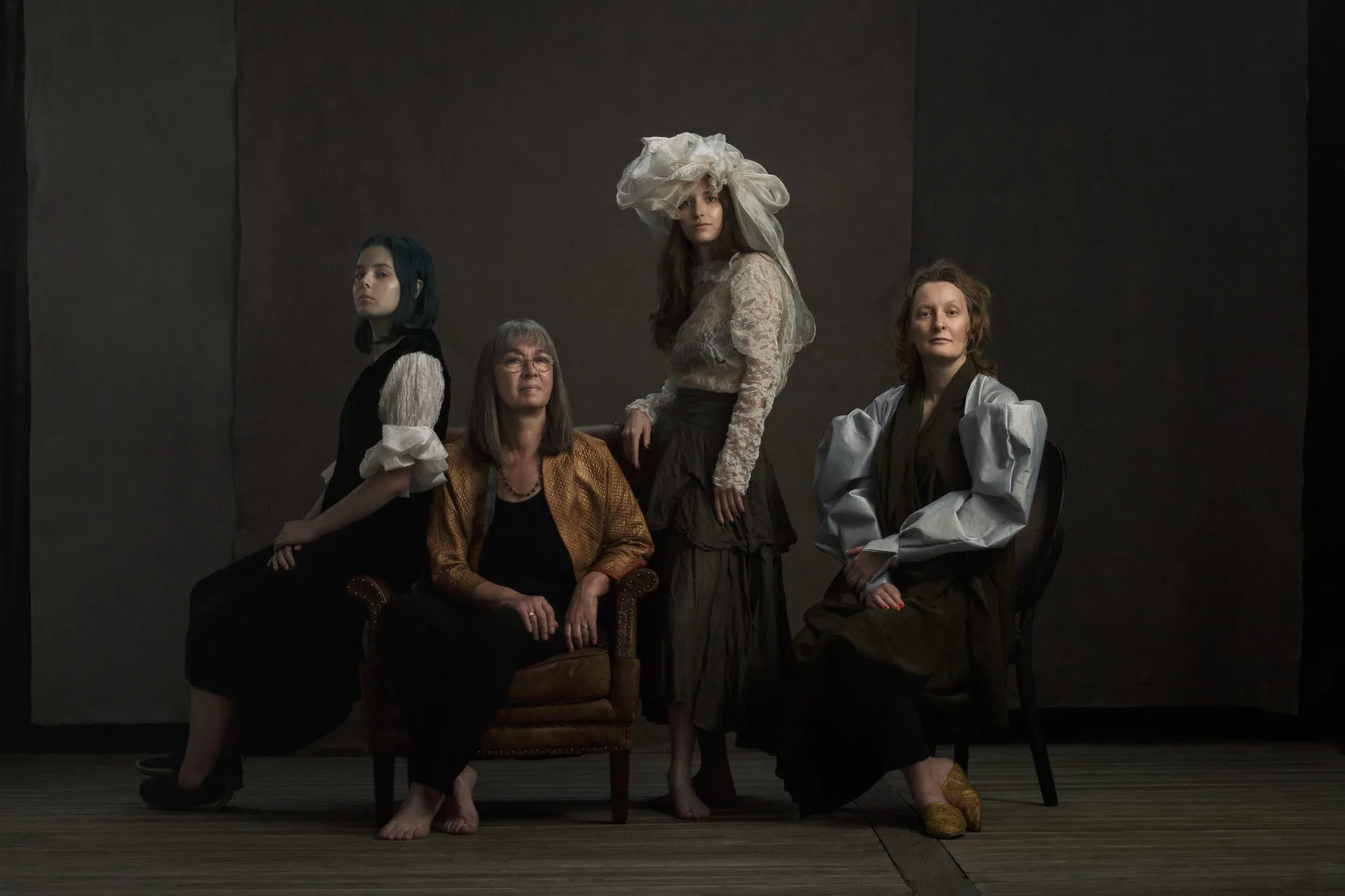 Four women of the Plavinsky family pose together in period-style clothes against a dark backdrop.