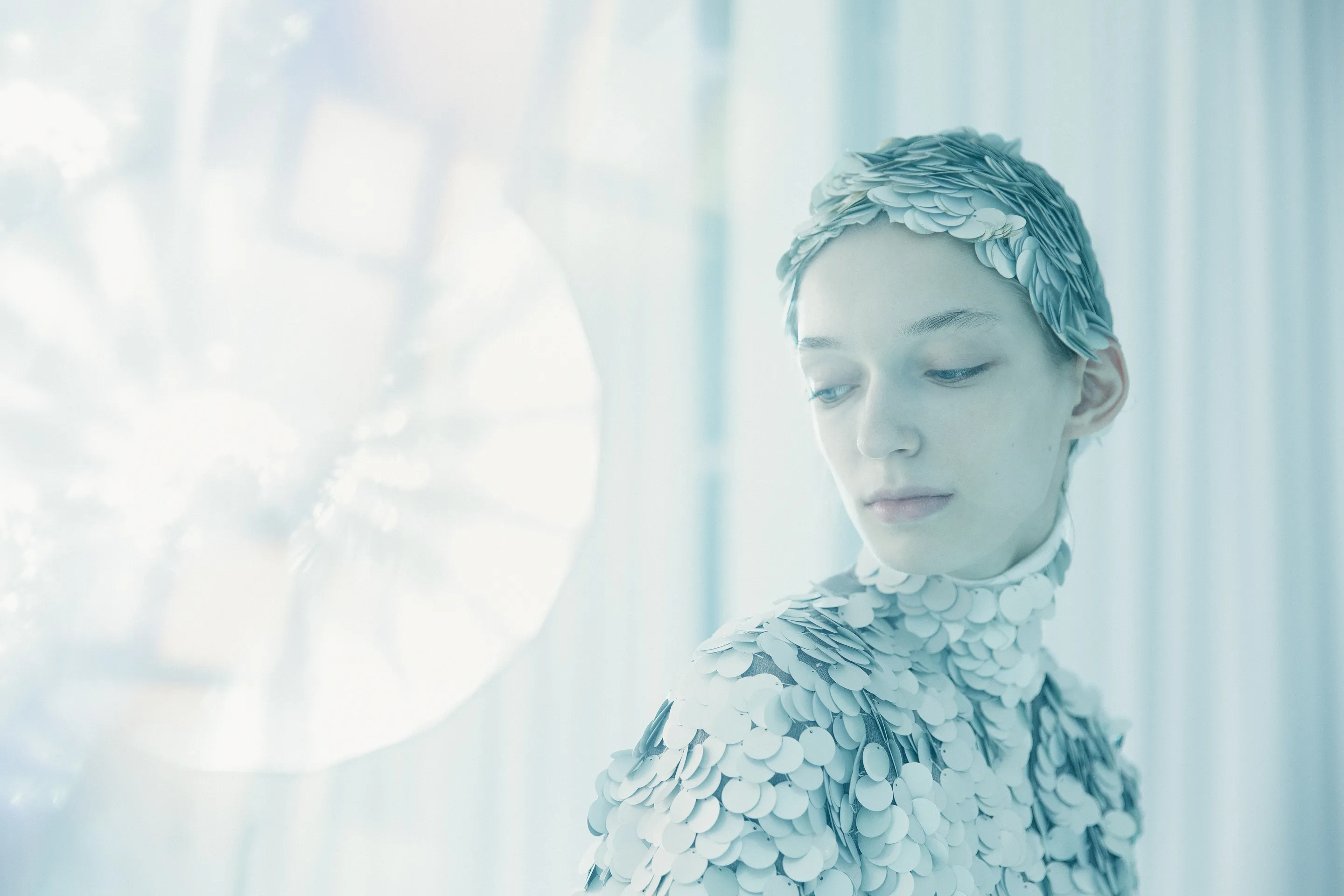 Photoband 2018 by Andrei Kovalev: a woman wears a pale, scaled headpiece in a soft-focus close-up.