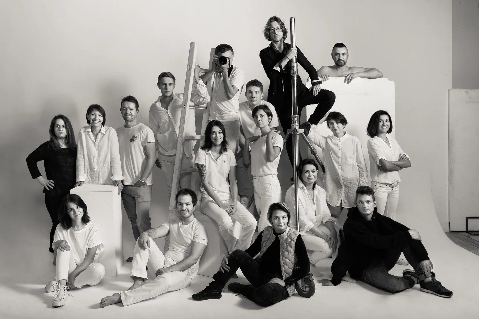 The course students and crew in a black-and-white group portrait in a white studio.