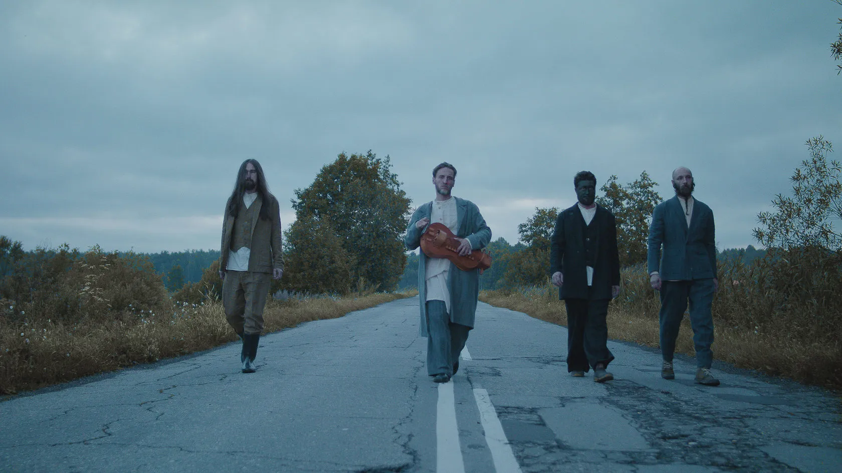 Infundibulum Divo by Andrei Kovalev: four figures walk along a misty country road in a scene from the fashion film.