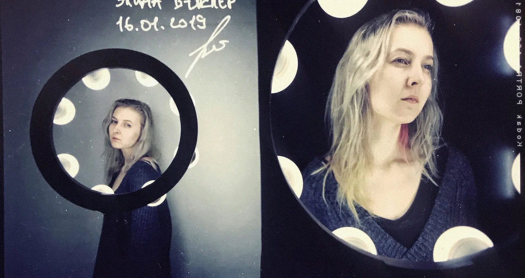 A test on 4×5 film: a woman framed by a ring of studio lights, full length and close up.