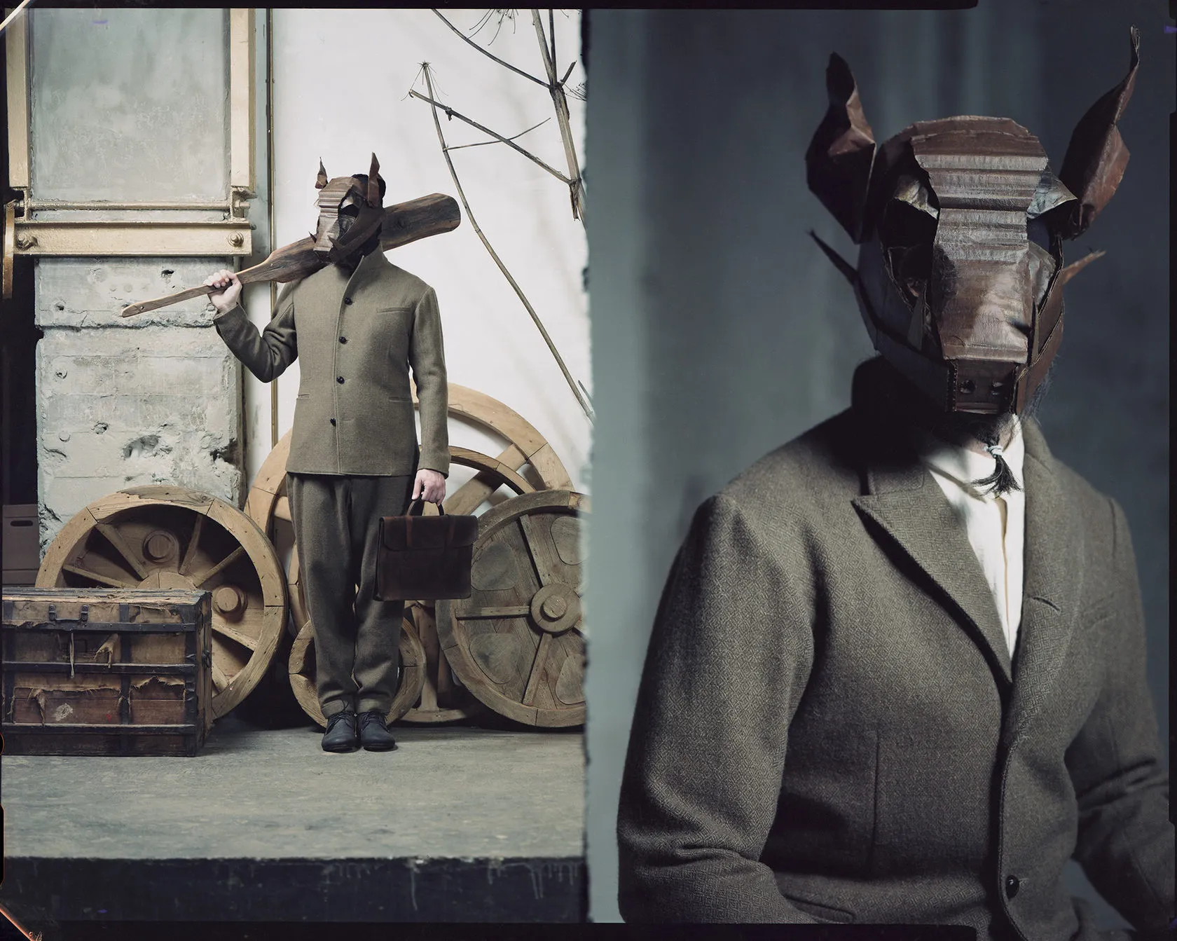 The man in the horned cardboard mask with a plank, full length among cart wheels and in close-up.