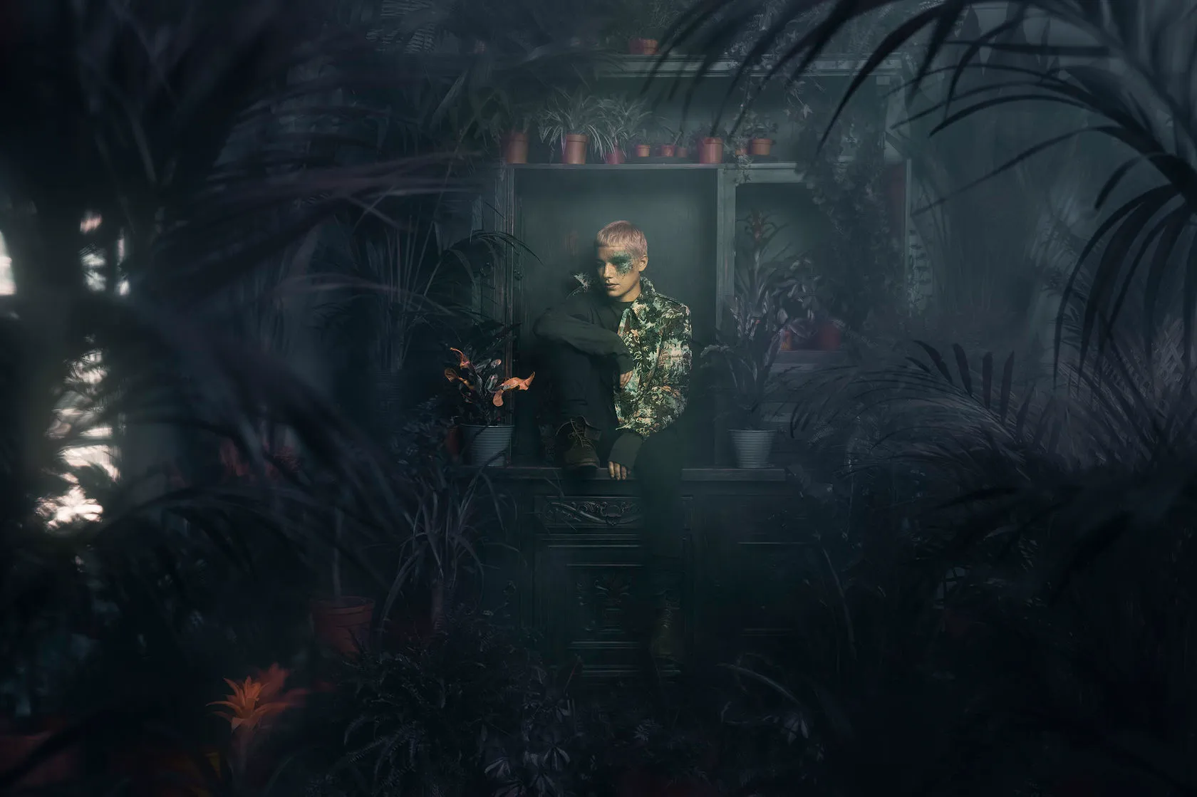 The model sits in a lit niche deep inside a dark wall of plants.