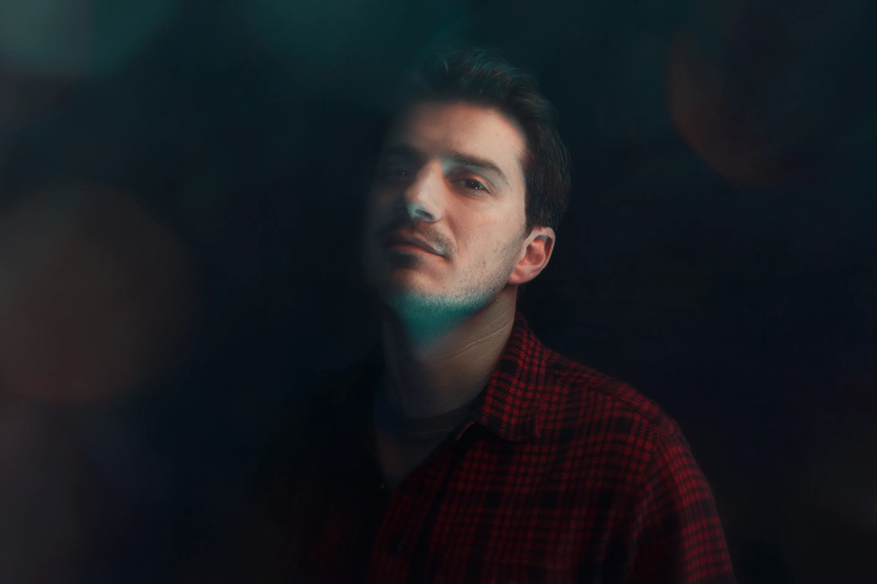 Sven Hansen-Løve press portfolio by Andrei Kovalev: a man's portrait is lit with soft, coloured lens flare.