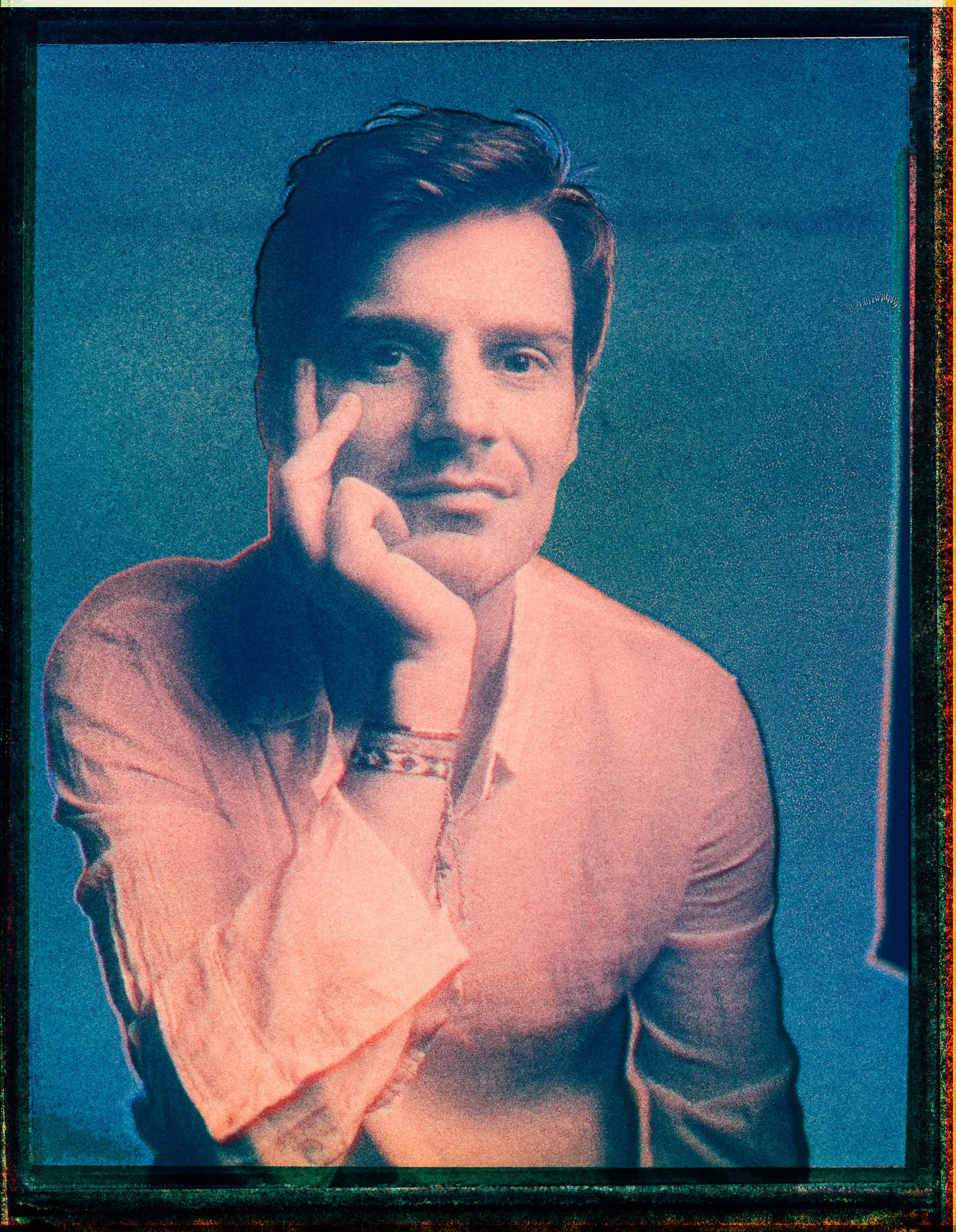 Sven, chin in hand, on instant film in blue and orange.
