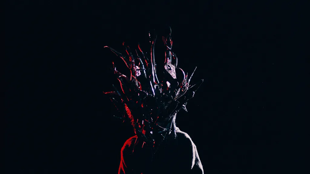 The spiky Chaos mask lit red from one side against black.