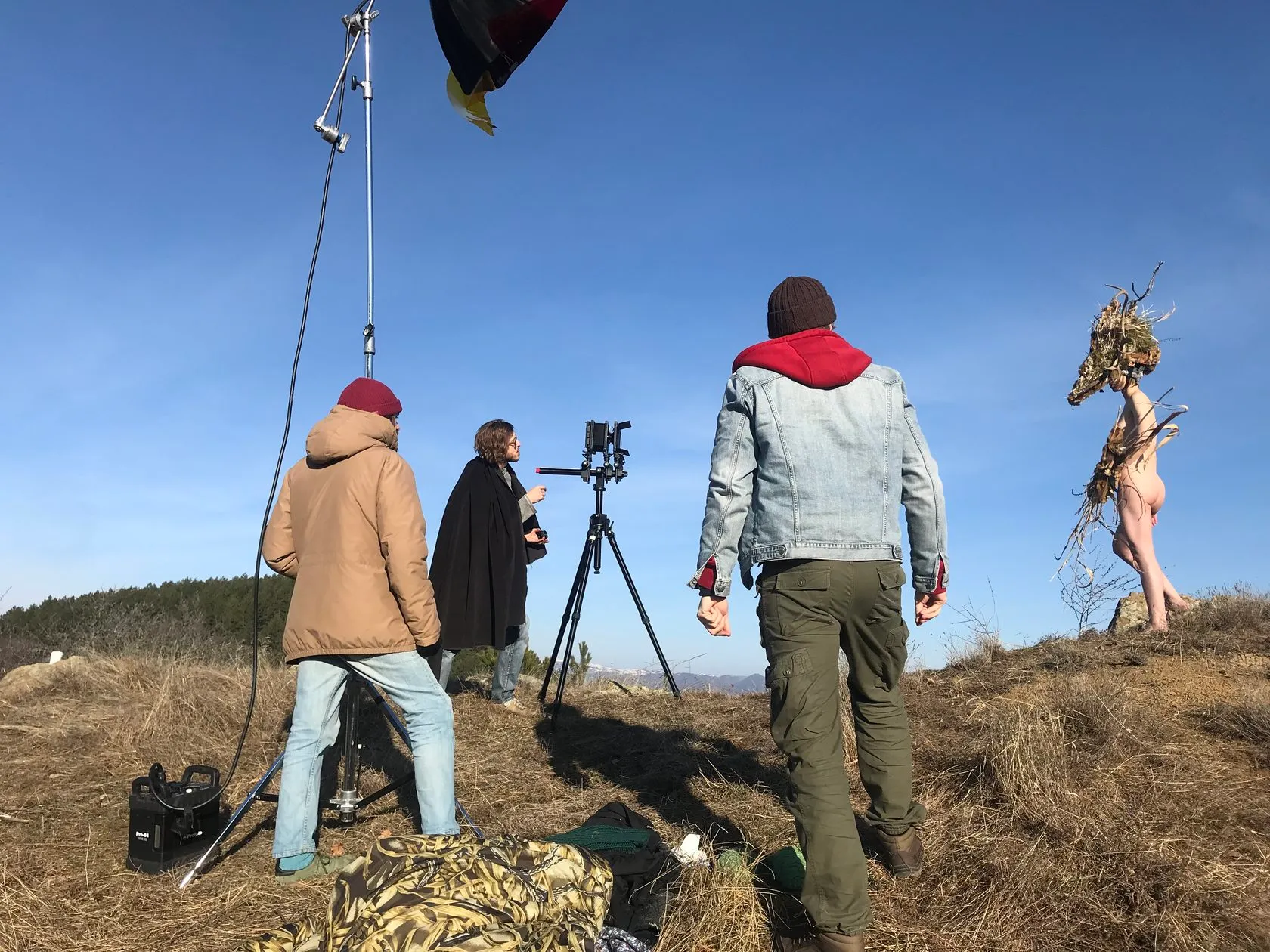 Behind the scenes: the crew and a large-format camera on a sunny hilltop, Dàli posing nearby.
