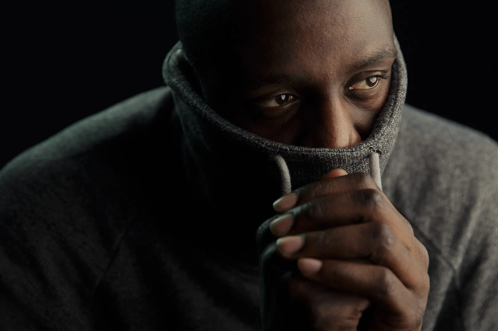Ibrahim Sissoko pulls a grey knitted collar up over his mouth.
