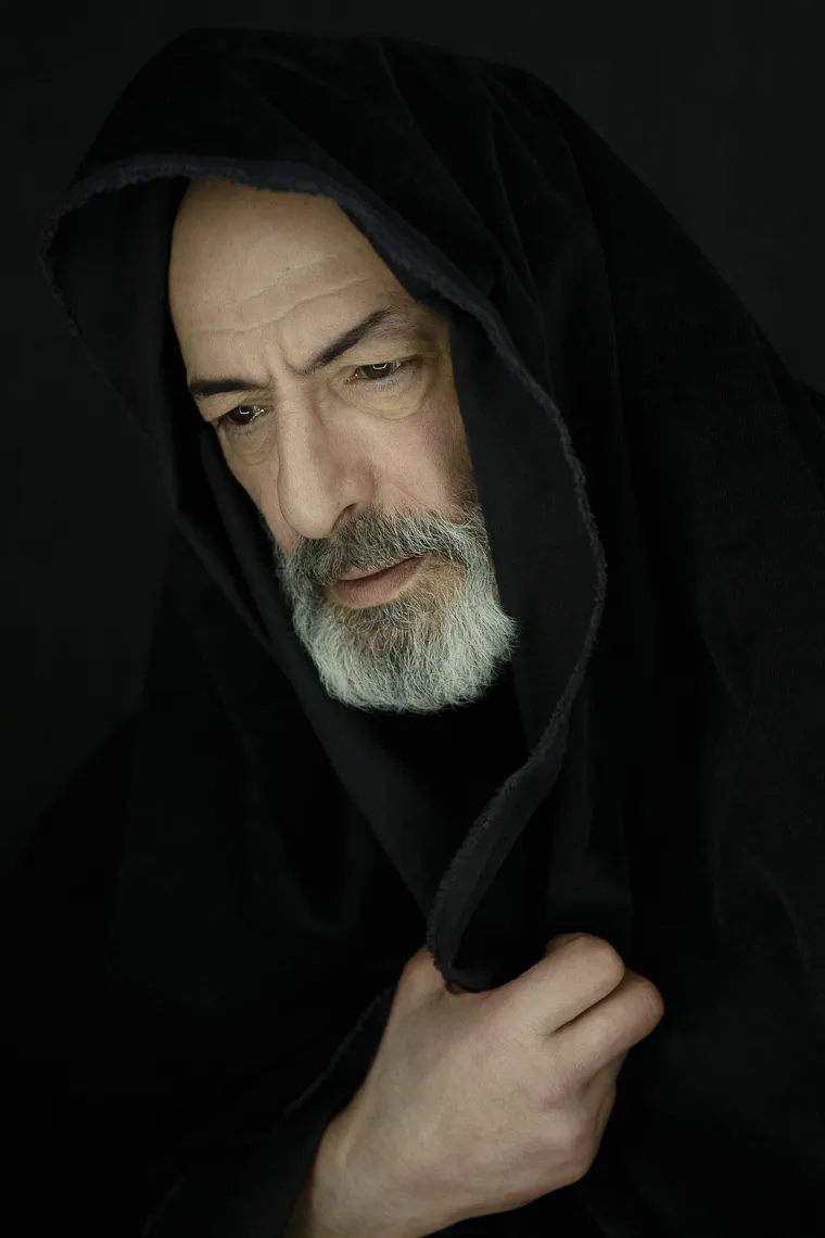 Zurab Kipshidze, grey-bearded, draws a black hood around his face.