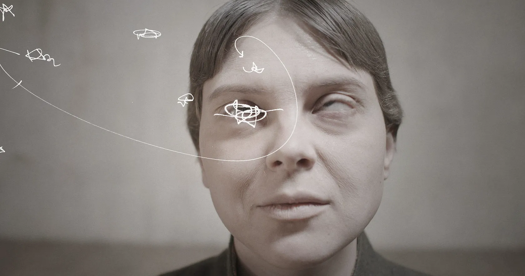 A woman’s face in close-up, white scribbles circling one eye.