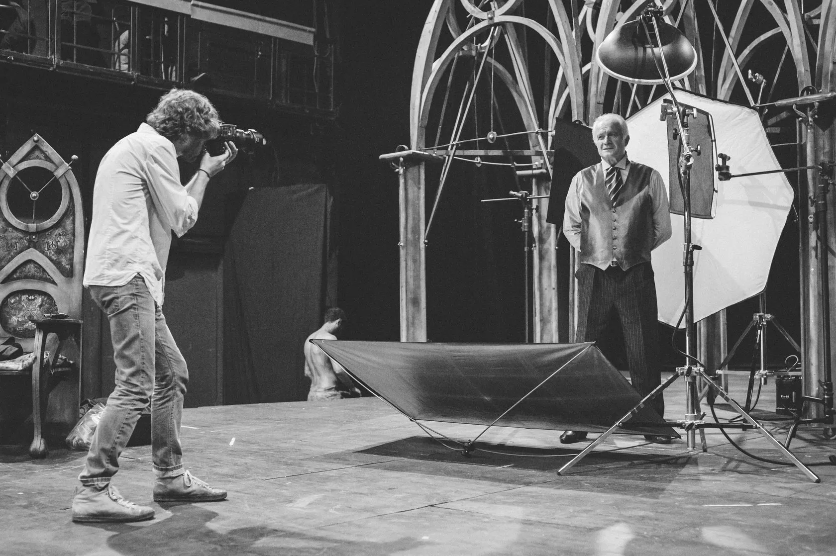 Behind the scenes: the photographer shoots an older actor in a waistcoat and tie.