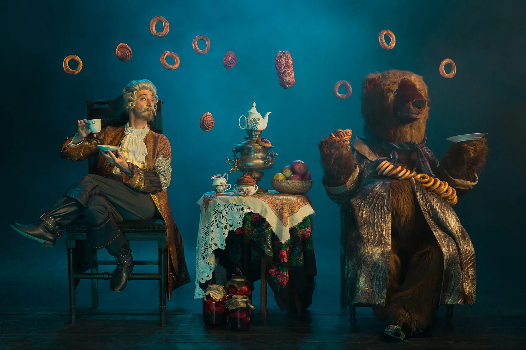 The Baron takes tea from a samovar with a bear, as bagels fly through the air.