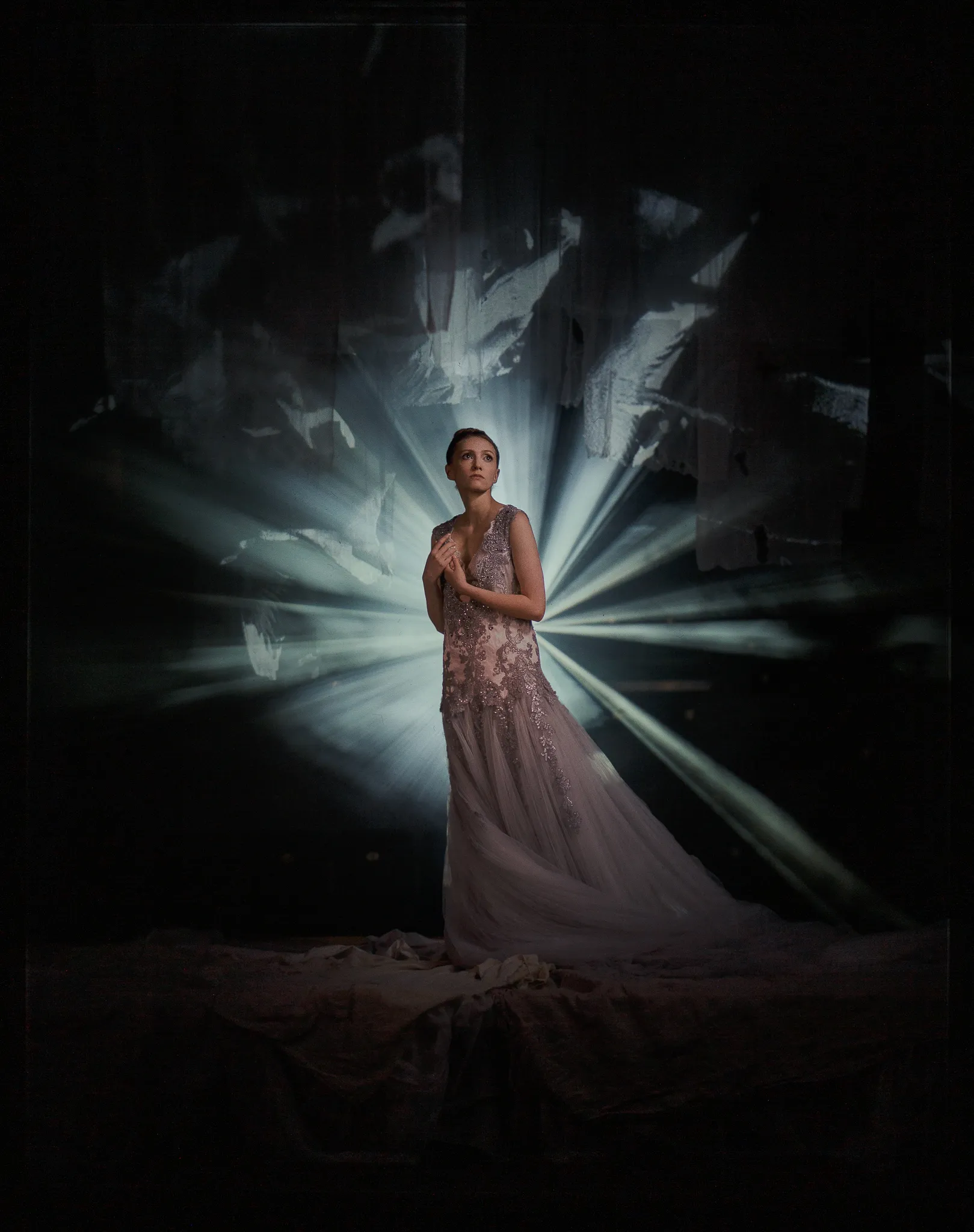 Maria Bolshova as Zarechnaya, in a pale embroidered gown, stands in a burst of light rays.