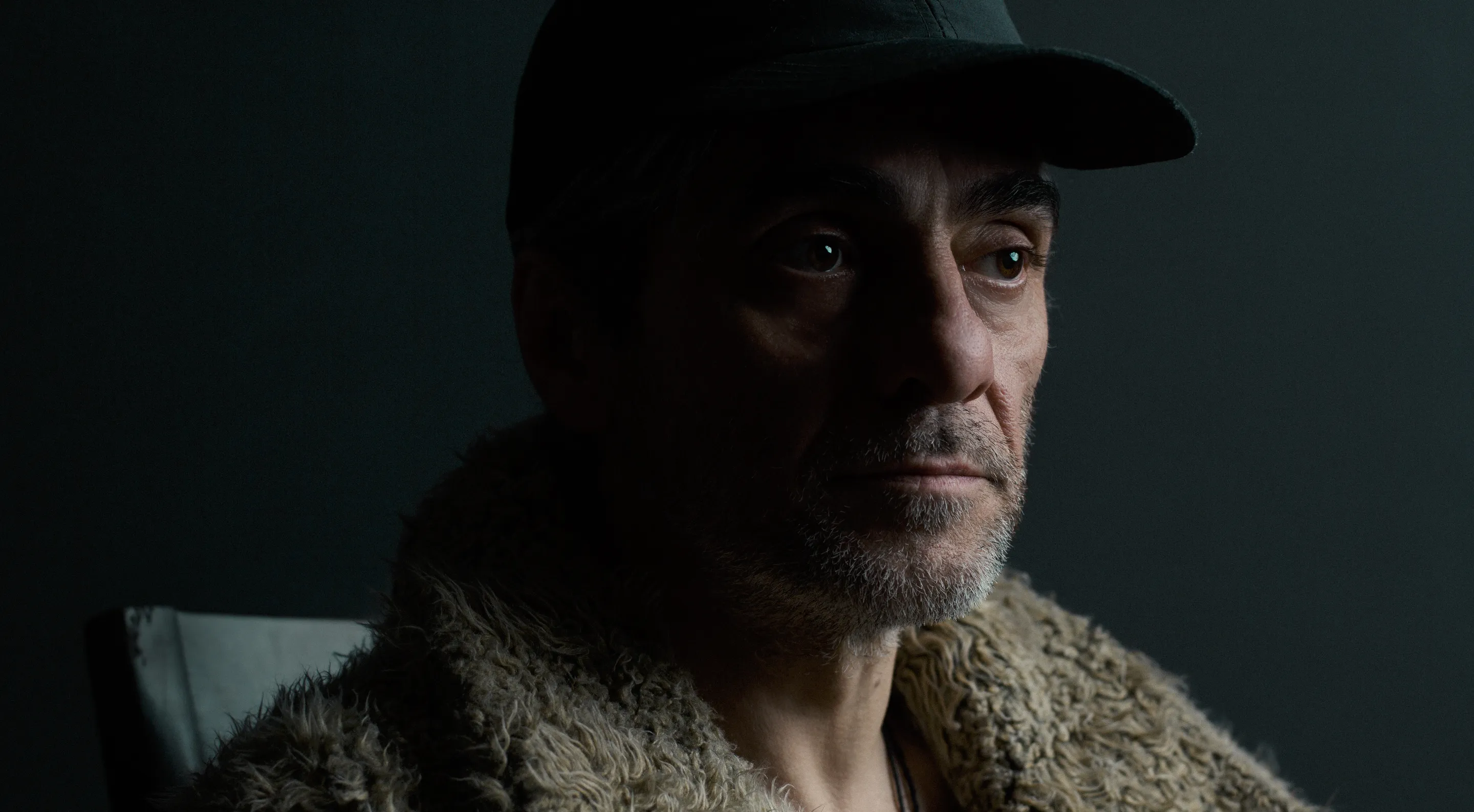 The Zoo Story key visual by Andrei Kovalev: a weathered man in a peaked cap looks past the camera in close-up.