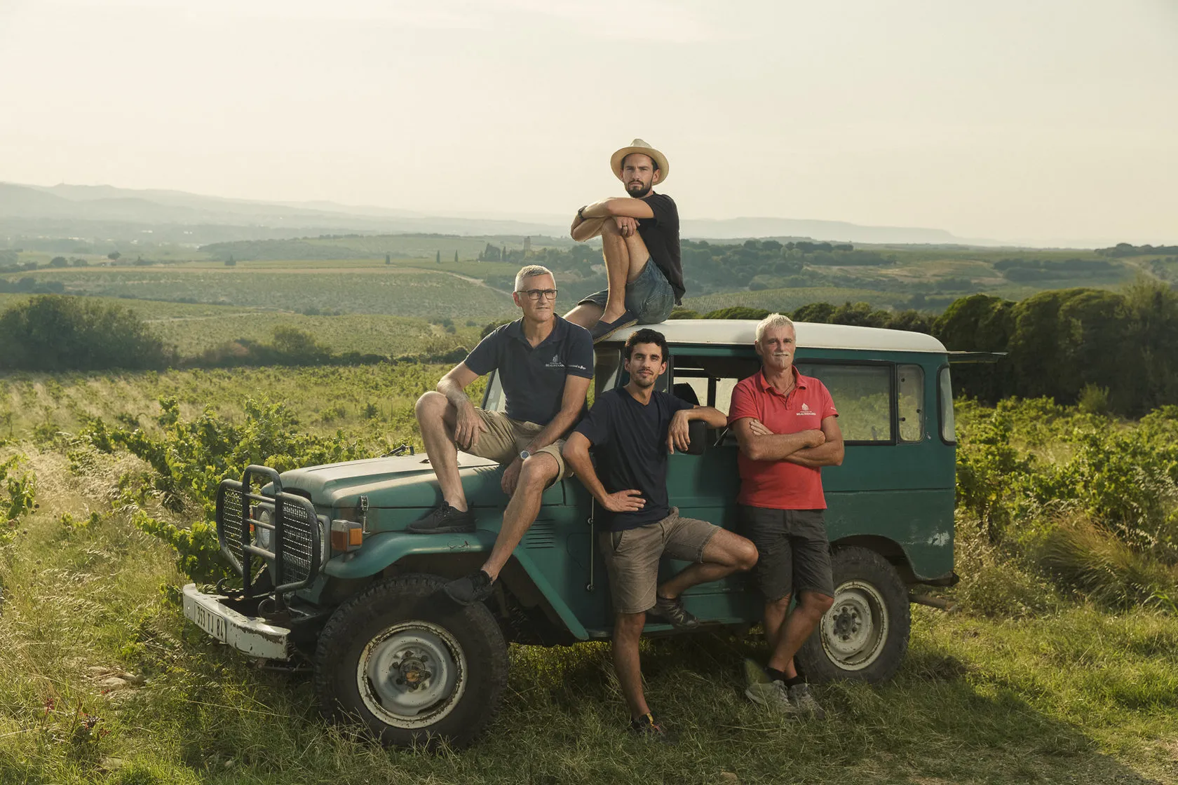 The Coulon family of Domaine Beaurenard on an old jeep in their vineyard.