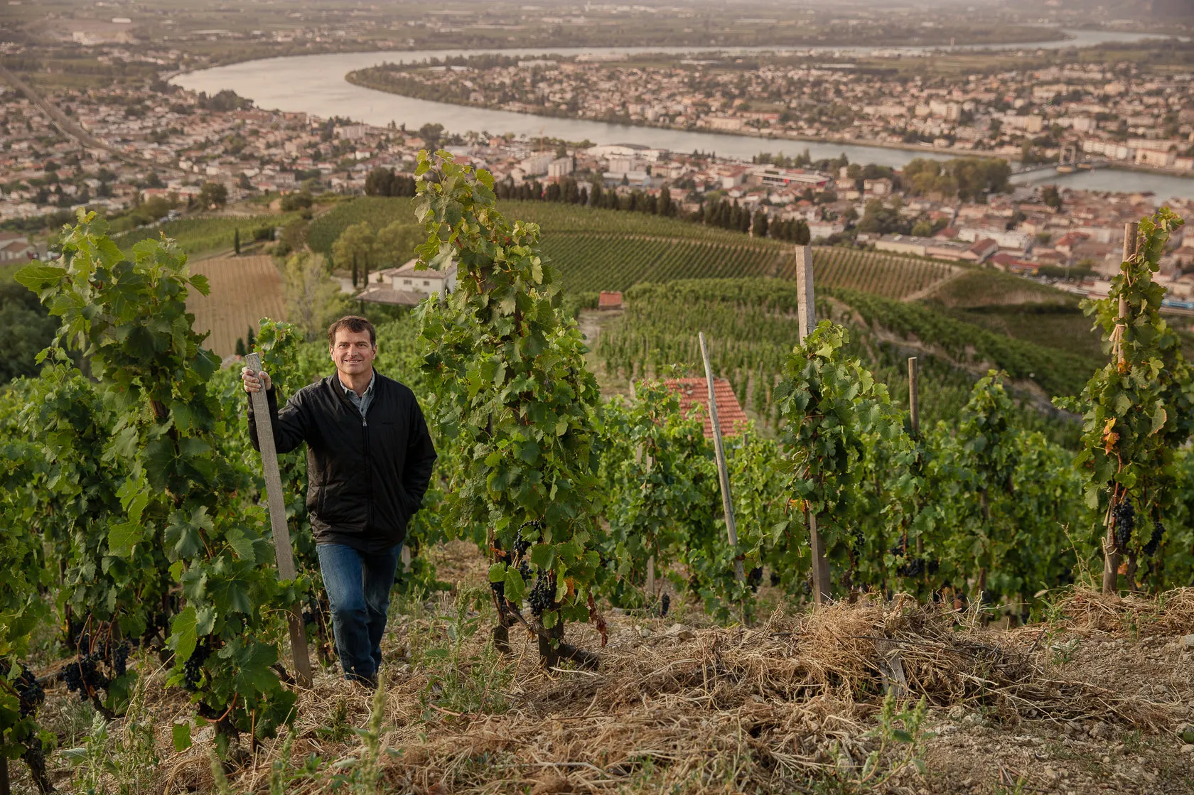 Jean-Louis Chave walks up a steep vineyard high above the river and the town.