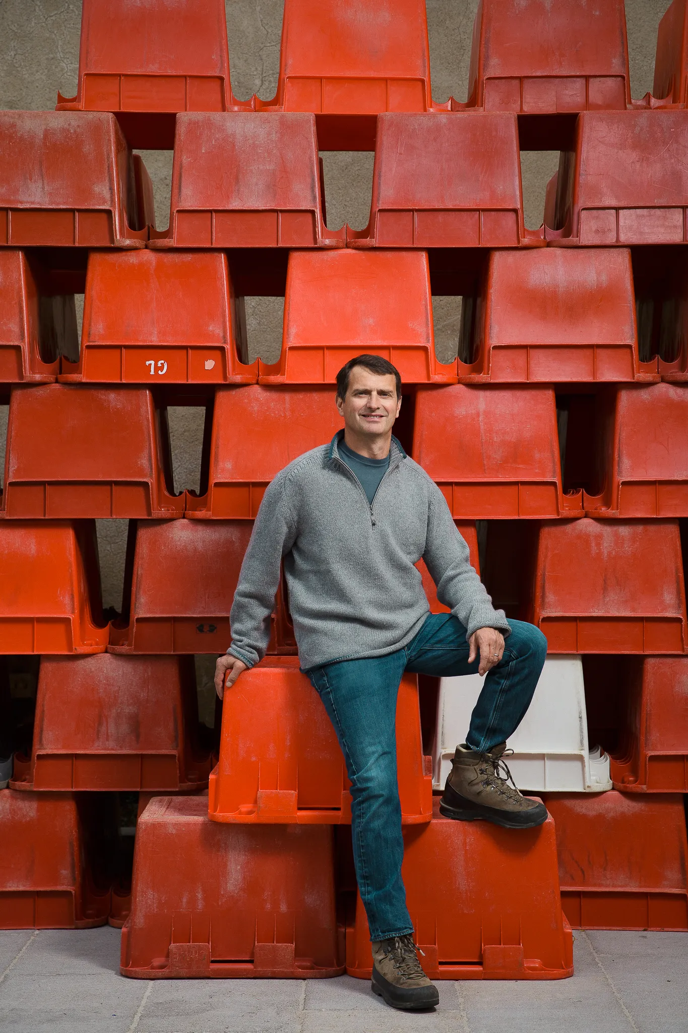 Jean-Louis Chave sits on a wall of stacked red grape crates.
