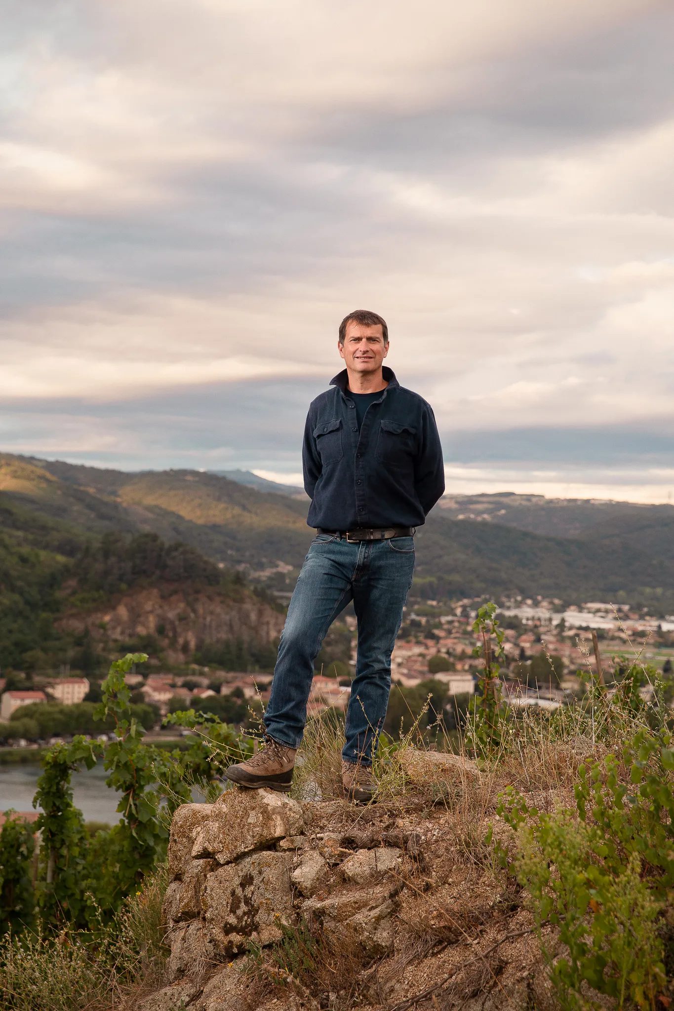 Jean-Louis Chave stands on a rocky outcrop above the valley, hands behind his back.