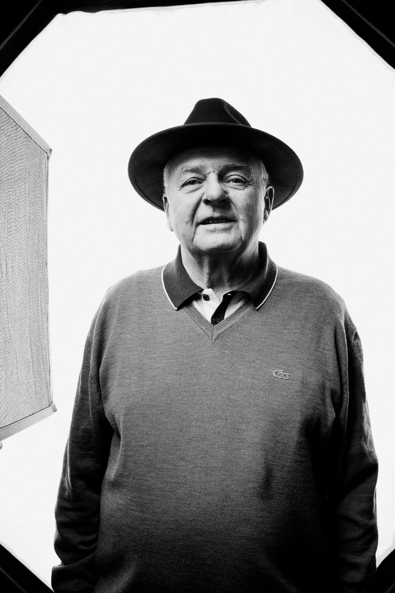 An older winemaker in a felt hat and a jumper, in black and white.
