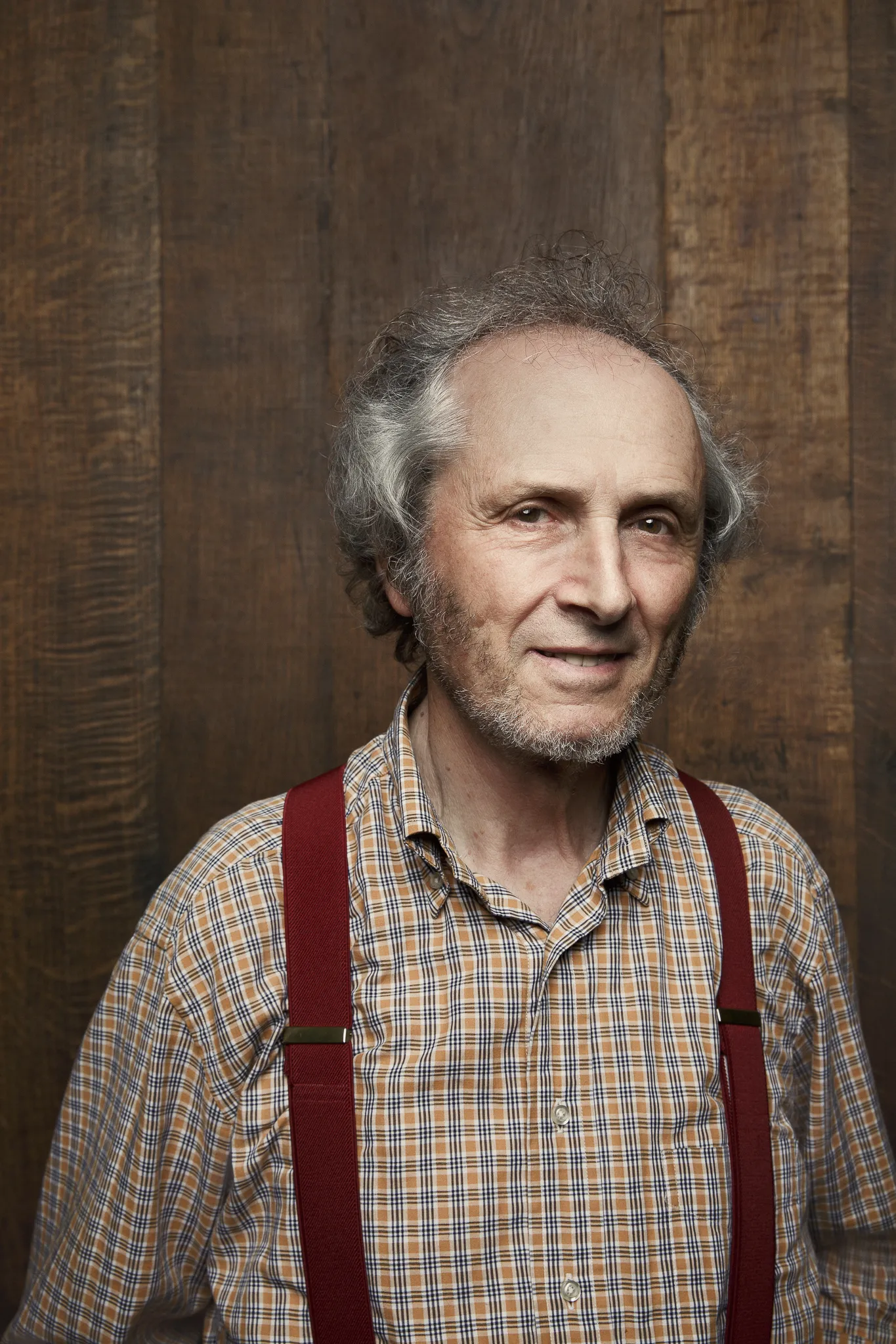 A smiling grey-haired winemaker at Giuseppe Mascarello, in a checked shirt and red braces.