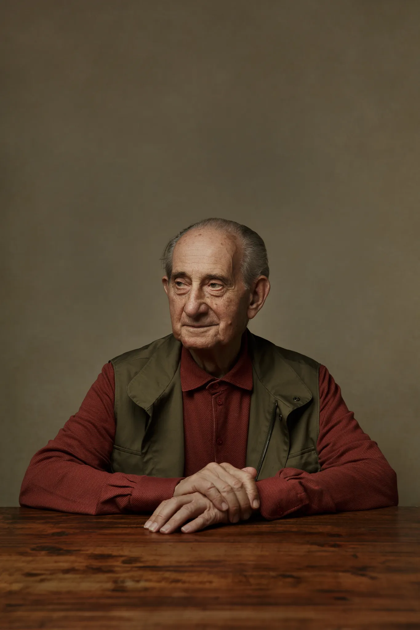 Vittorio Frescobaldi in a red shirt and green waistcoat sits at a wooden table.