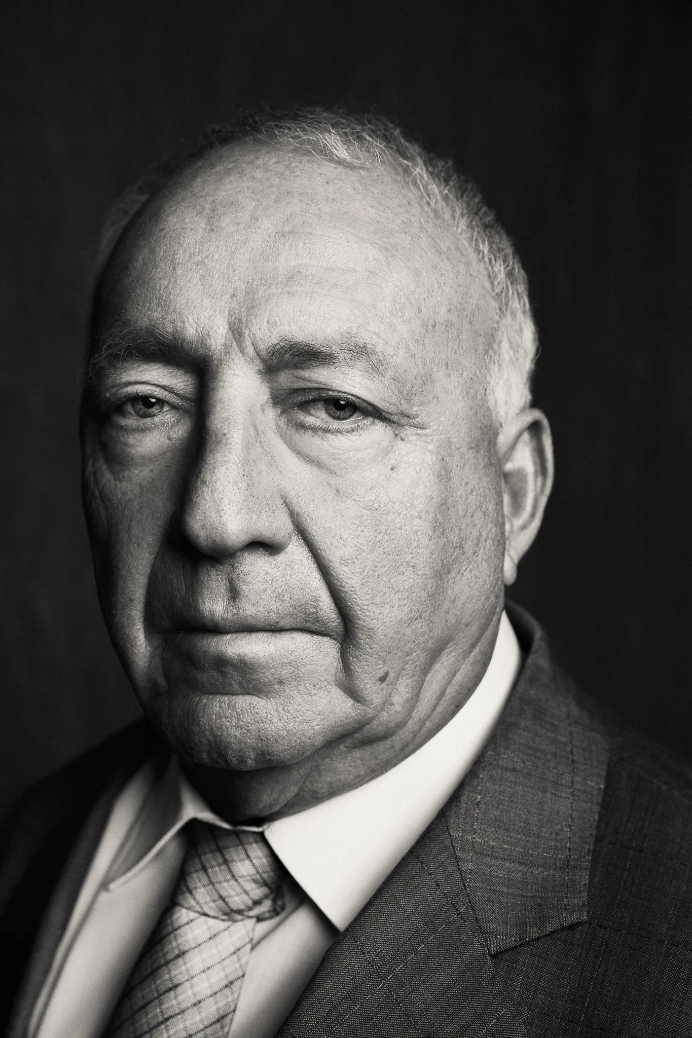 Robert Azaryan in a suit and patterned tie, close up in black and white.