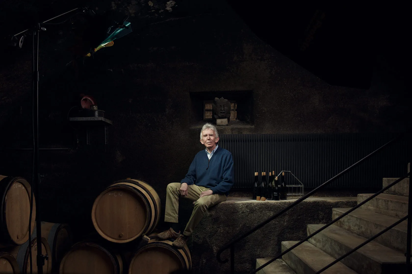 Jean-Charles Le Bault de la Morinière sits among barrels in a dark cellar.